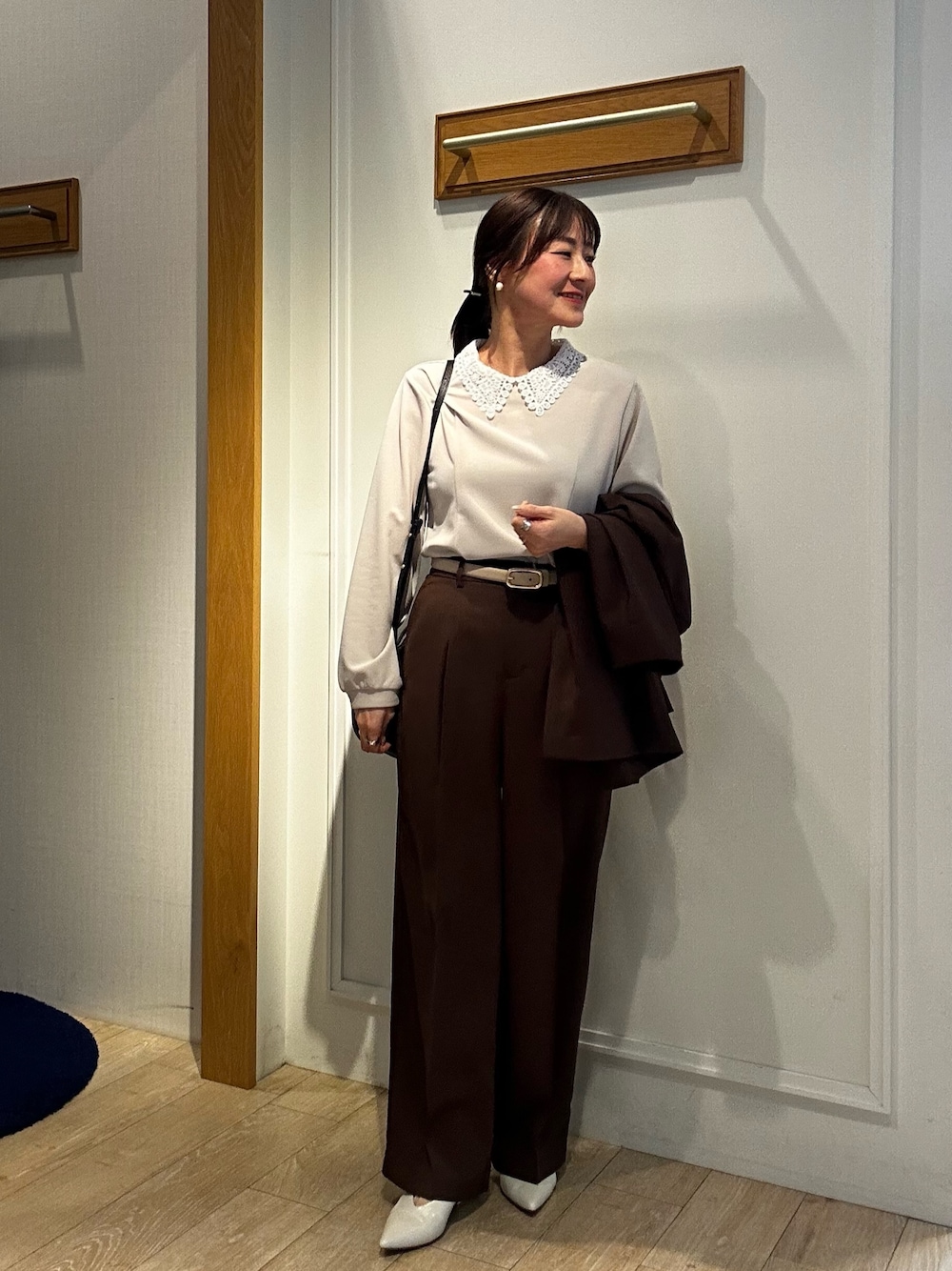 ブラック系のショルダーバッグ、ベージュ系のシャツ/ブラウス、ブラウン系のノーカラージャケットを着用したレディースの春コーディネートの1枚目の写真