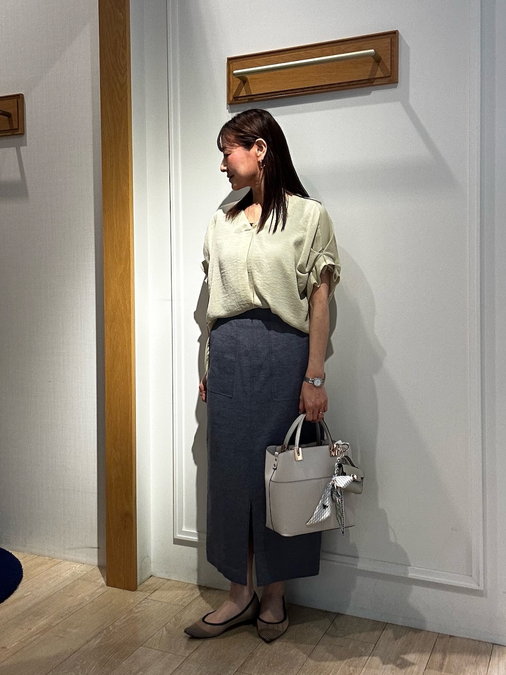 イエロー系のシャツ/ブラウス、ブルー系のスカート、グレー系のTシャツ/カットソーを着用したレディースの春コーディネートの1枚目の写真