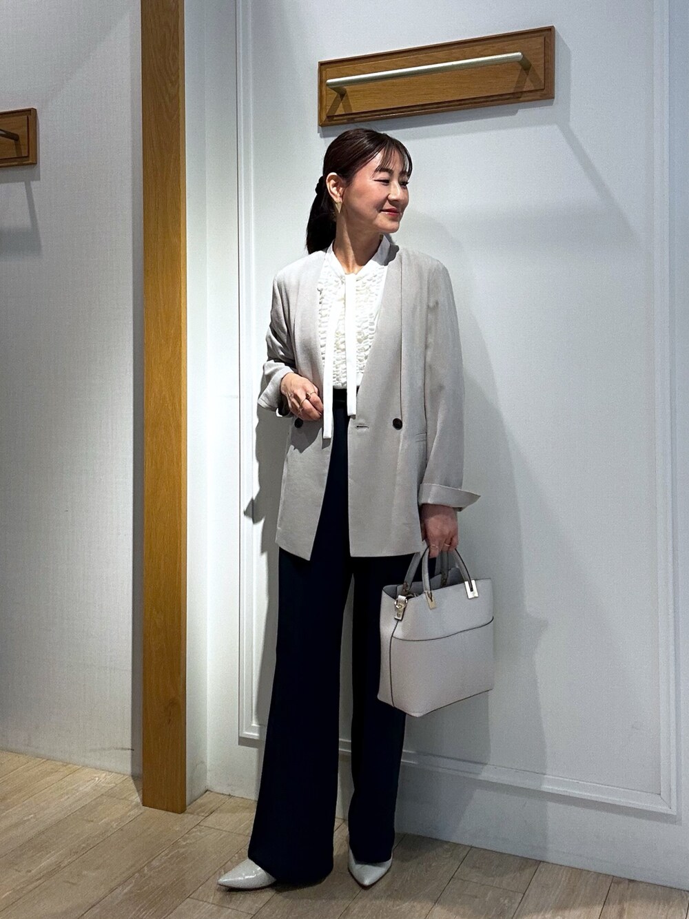 ベージュ系のノーカラージャケット、ホワイト系のシャツ/ブラウス、ブルー系のその他パンツを着用したレディースの春コーディネートの1枚目の写真