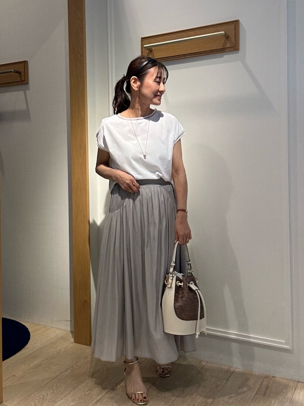 ホワイト系のTシャツ/カットソー、ベージュ系のスカート、ホワイト系のブルゾンを着用したレディースの春コーディネートの1枚目の写真