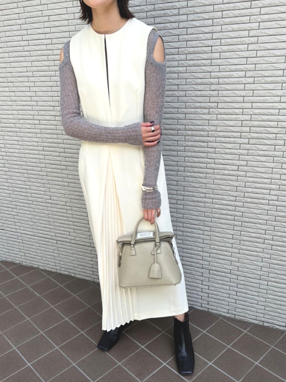 ホワイト系のジャンパースカートを着用したレディースの秋コーディネートの1枚目の写真