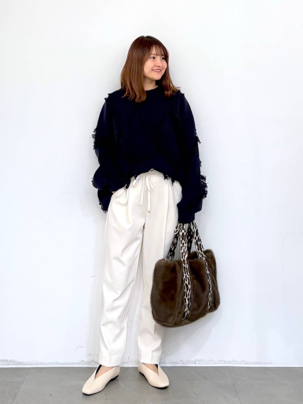 ホワイト系のその他パンツ、ホワイト系のパンプス、ブラウン系のトートバッグを着用したレディースの秋コーディネートの1枚目の写真