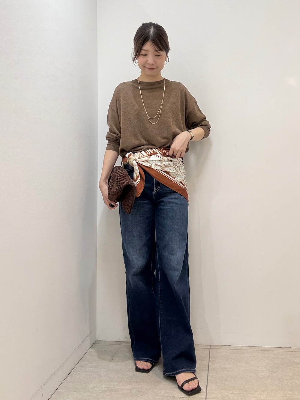 ブラウン系のカーディガン/ボレロ、ブラック系のタンクトップ、ブルー系のデニムパンツを着用したレディースの夏コーディネートの1枚目の写真