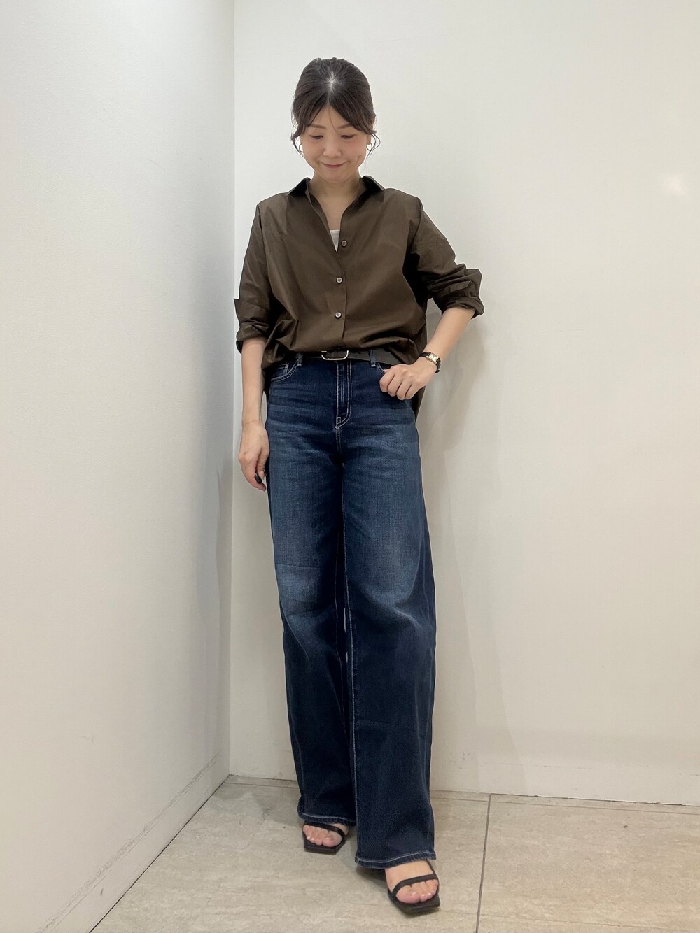 ベージュ系のタンクトップ、ブルー系のデニムパンツを着用したレディースの夏コーディネートの1枚目の写真