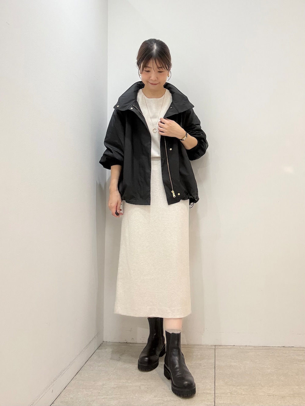 ホワイト系のTシャツ/カットソー、ホワイト系のスカート、ブラック系のブルゾンを着用したレディースの秋コーディネートの1枚目の写真