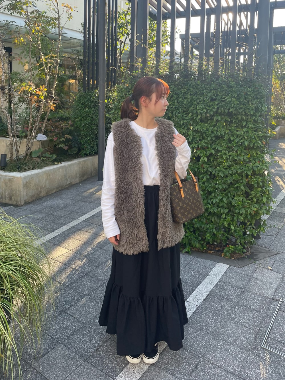 ホワイト系のTシャツ/カットソー、グレー系のベスト、ブラック系のスカートを着用したレディースの秋コーディネートの1枚目の写真