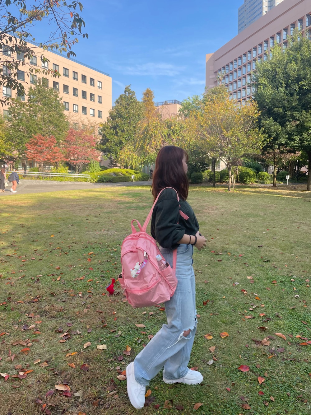 グリーン系のパーカー、ブルー系のデニムパンツ、ピンク系のバックパック/リュックを着用したレディースの秋コーディネートの1枚目の写真