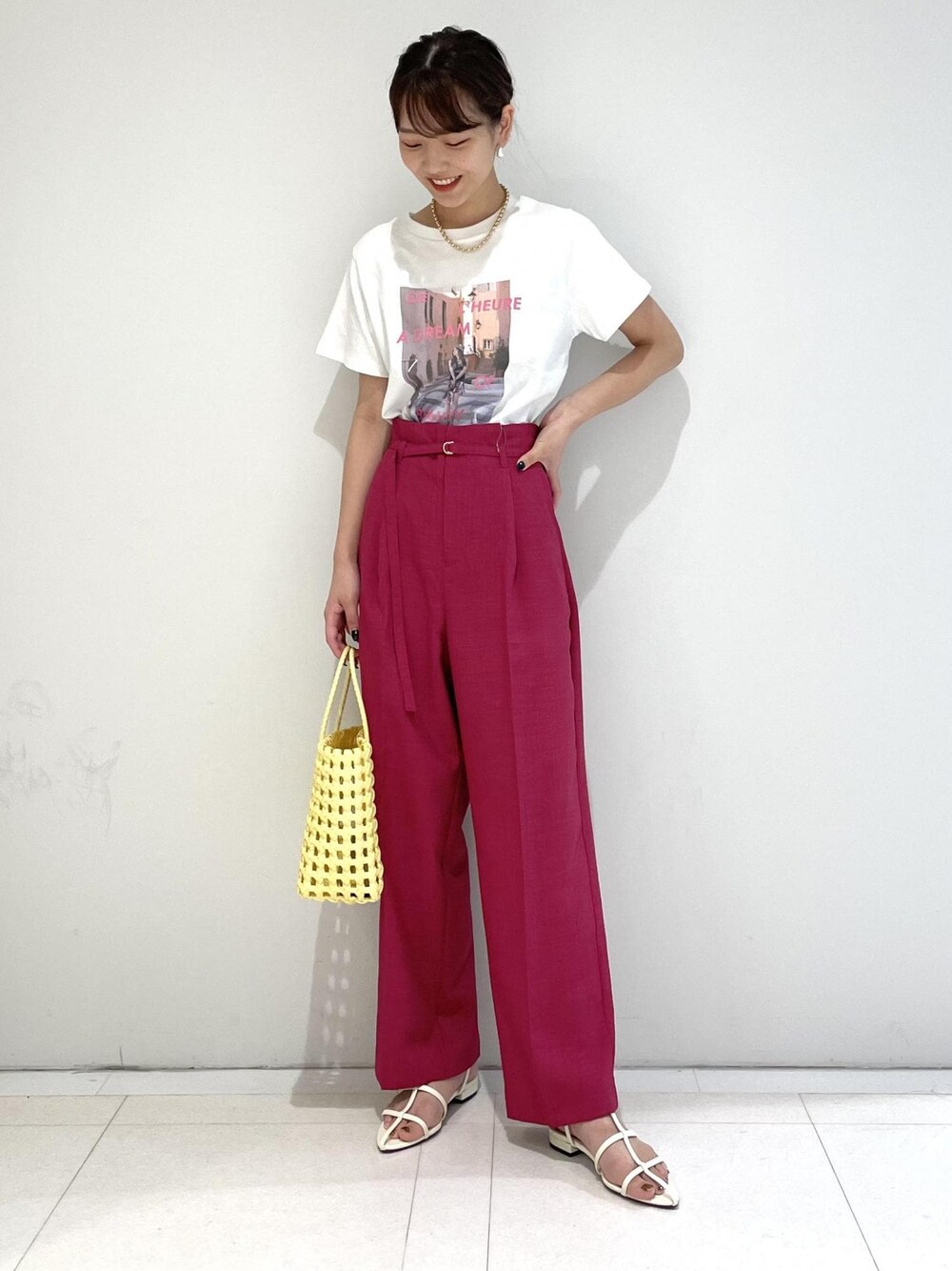 ピンク系のスラックス、ホワイト系のサンダル、ホワイト系のTシャツ/カットソーを着用したレディースの夏コーディネートの1枚目の写真