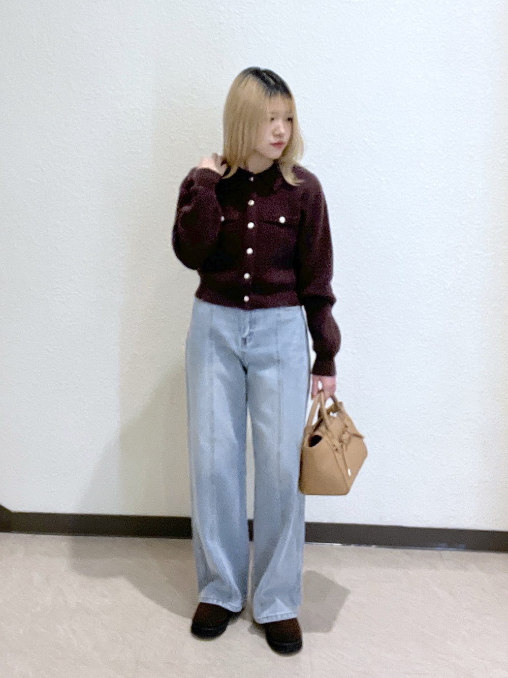 ブラウン系のニット/セーター、ベージュ系のトートバッグ、ブルー系のデニムパンツを着用したレディースの秋コーディネートの1枚目の写真