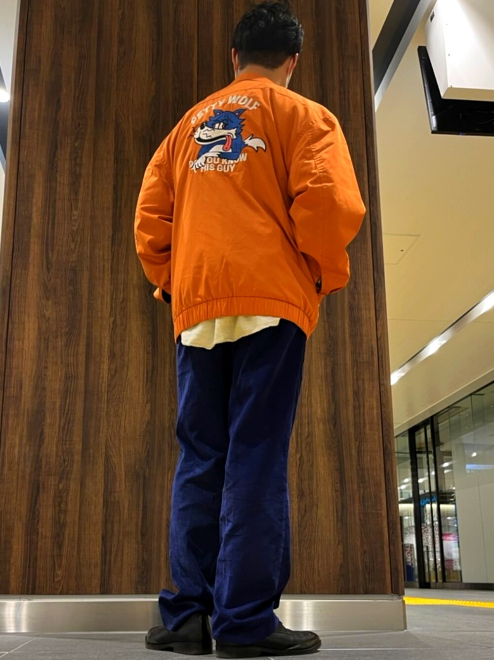 オレンジ系のブルゾン、ブラック系のボディバッグ/ウエストポーチ、ホワイト系のシャツ/ブラウスを着用したメンズの春コーディネートの2枚目の写真