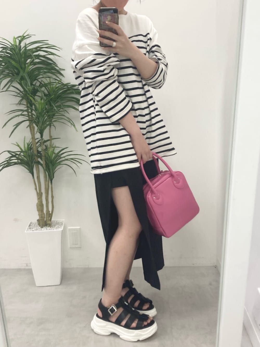 ブラック系のTシャツ/カットソー、ブラック系のスカート、ピンク系のショルダーバッグを着用したレディースの春コーディネートの2枚目の写真