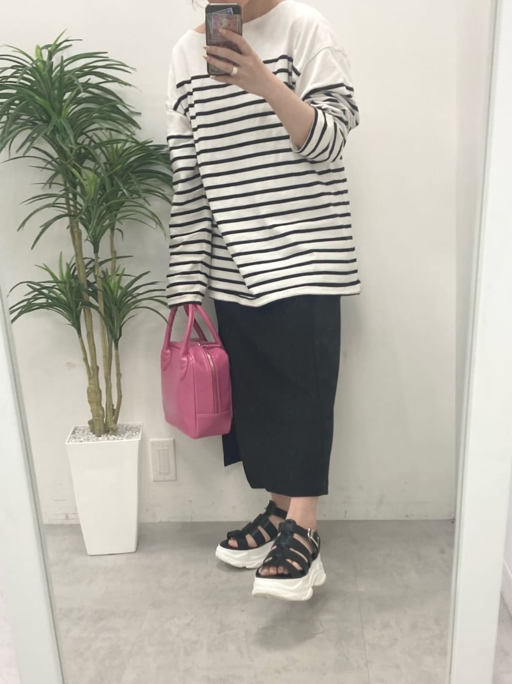 ブラック系のTシャツ/カットソー、ブラック系のスカート、ピンク系のショルダーバッグを着用したレディースの春コーディネートの3枚目の写真