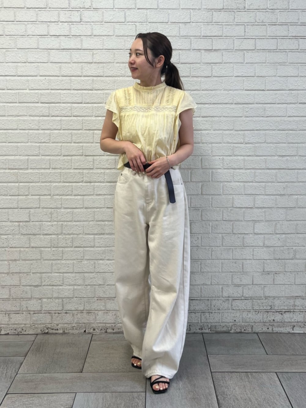 イエロー系のシャツ/ブラウス、ホワイト系のデニムパンツ、ブラウン系のベルトを着用したレディースの夏コーディネートの1枚目の写真