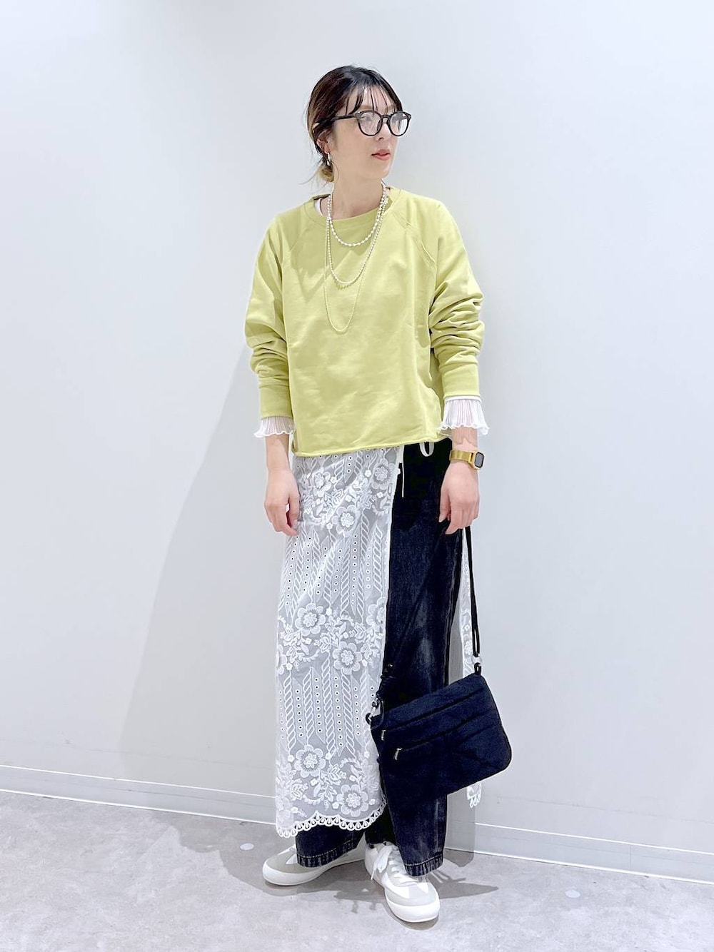 ホワイト系のスニーカー、ブラック系のデニムパンツ、ホワイト系のTシャツ/カットソーを着用したレディースの秋コーディネートの1枚目の写真