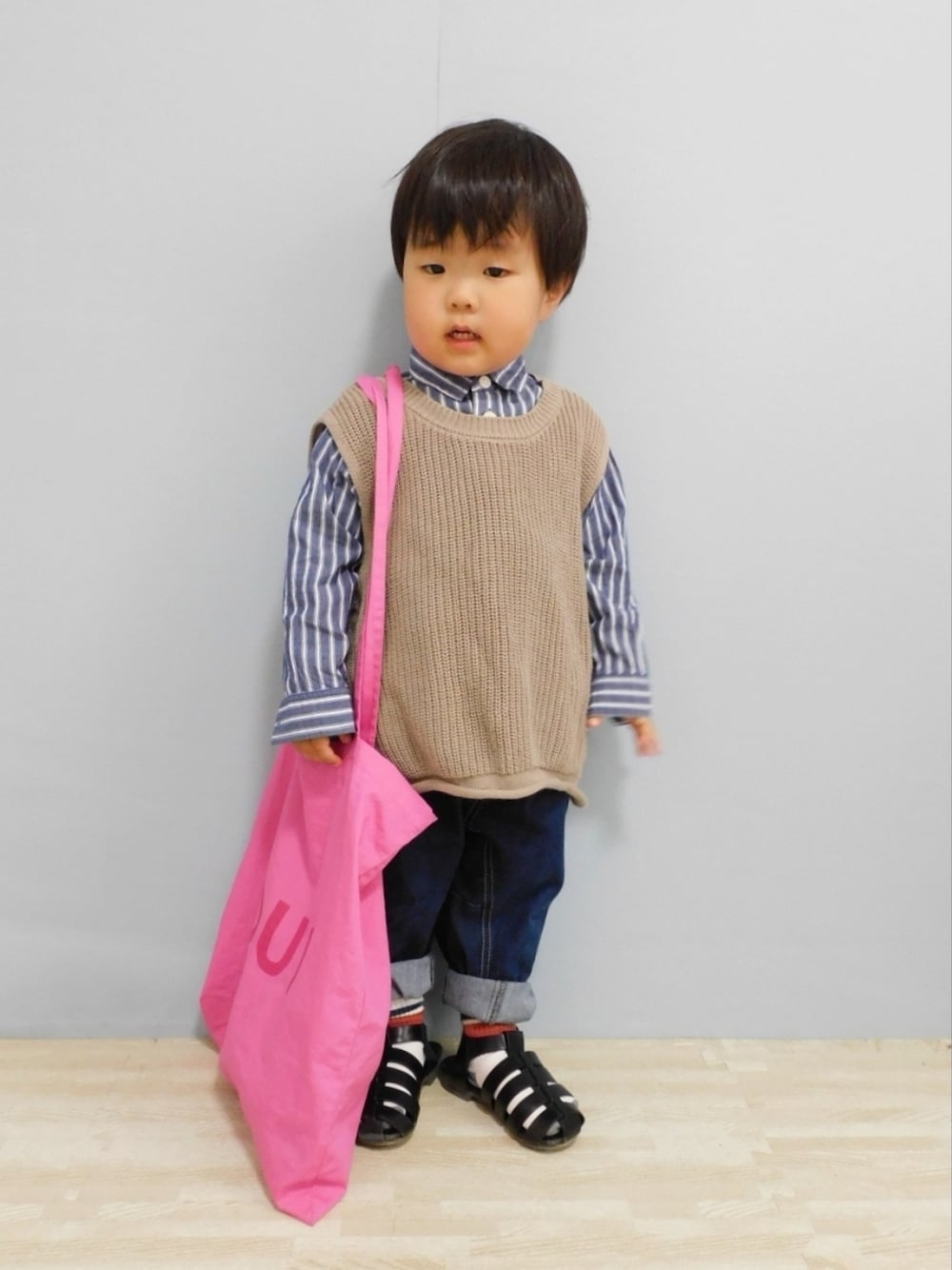 ベージュ系のベスト、ブルー系のシャツ/ブラウス、ブルー系のデニムパンツを着用したキッズの春コーディネートの1枚目の写真