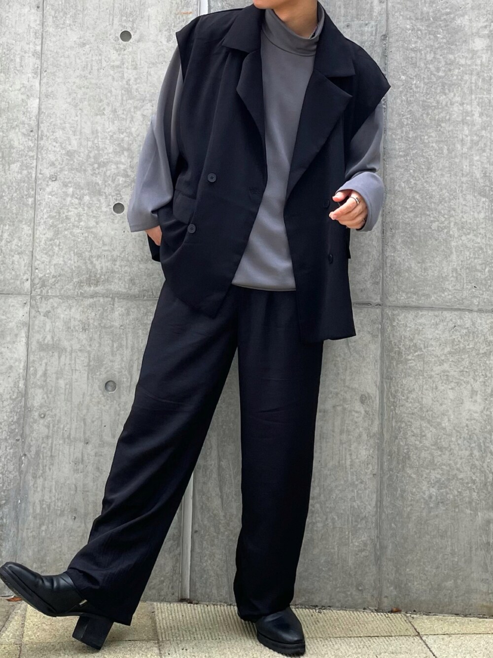 ブラック系のベスト、グレー系のTシャツ/カットソー、ブラック系のスラックスを着用したメンズの秋コーディネートの1枚目の写真