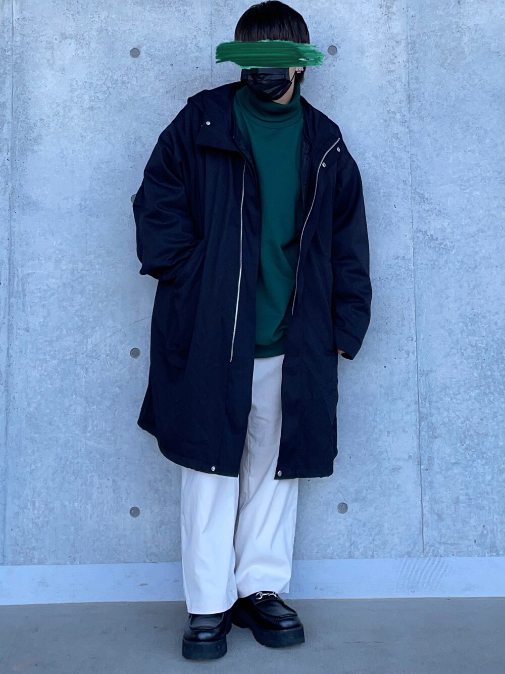 グリーン系のスウェット、ブラック系のモッズコート、ホワイト系のスラックスを着用したメンズの冬コーディネートの1枚目の写真