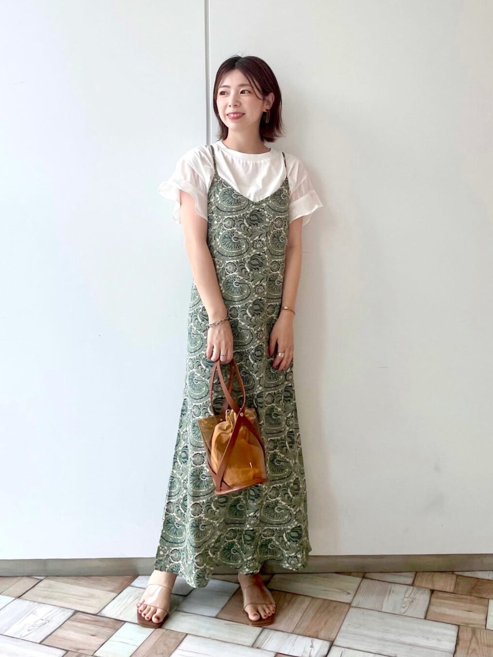 ホワイト系のTシャツ/カットソー、グリーン系のワンピース、イエロー系のショルダーバッグを着用したレディースの夏コーディネートの1枚目の写真