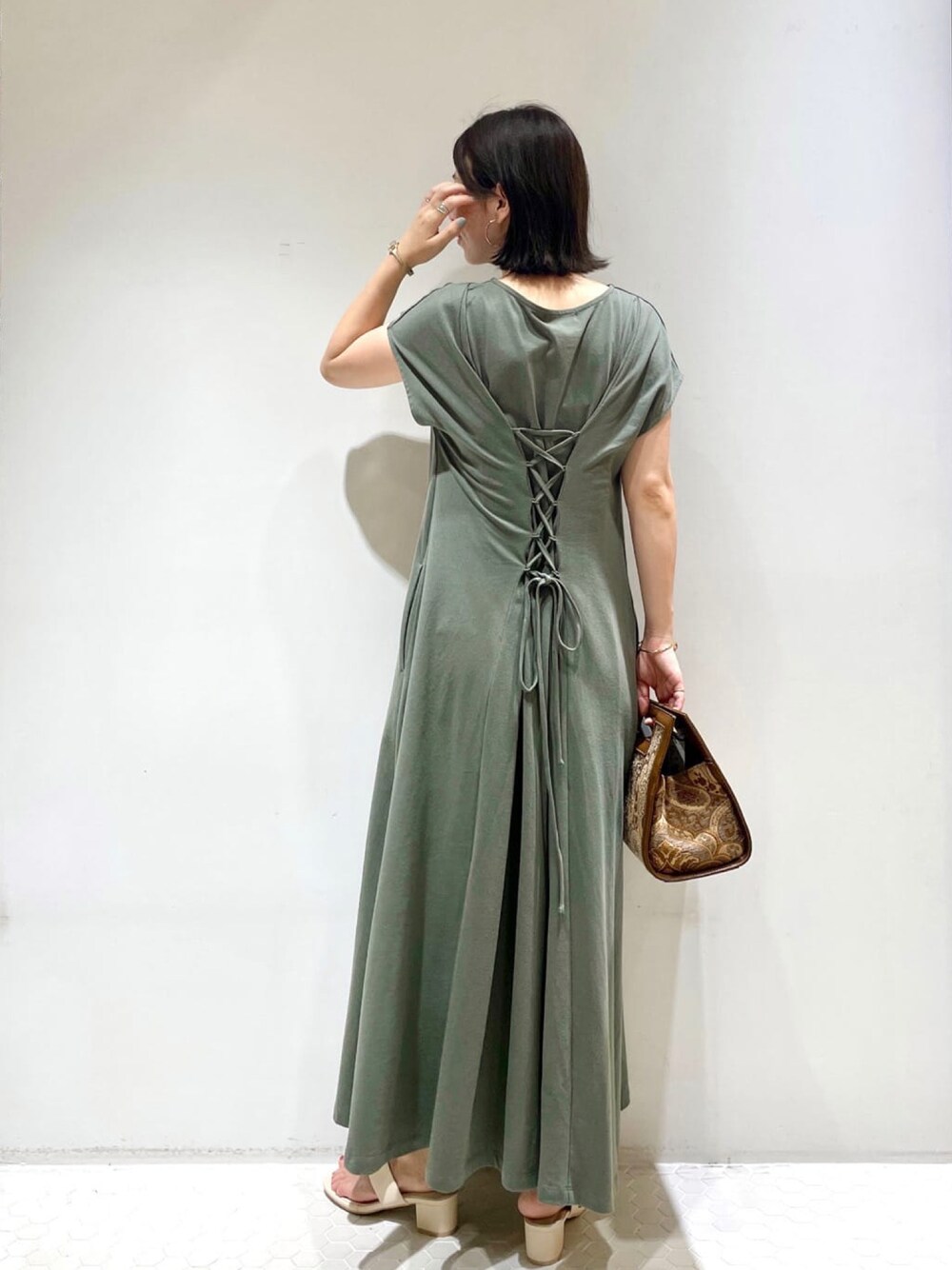 グリーン系のワンピース、ブルー系のハンドバッグを着用したレディースの夏コーディネートの1枚目の写真