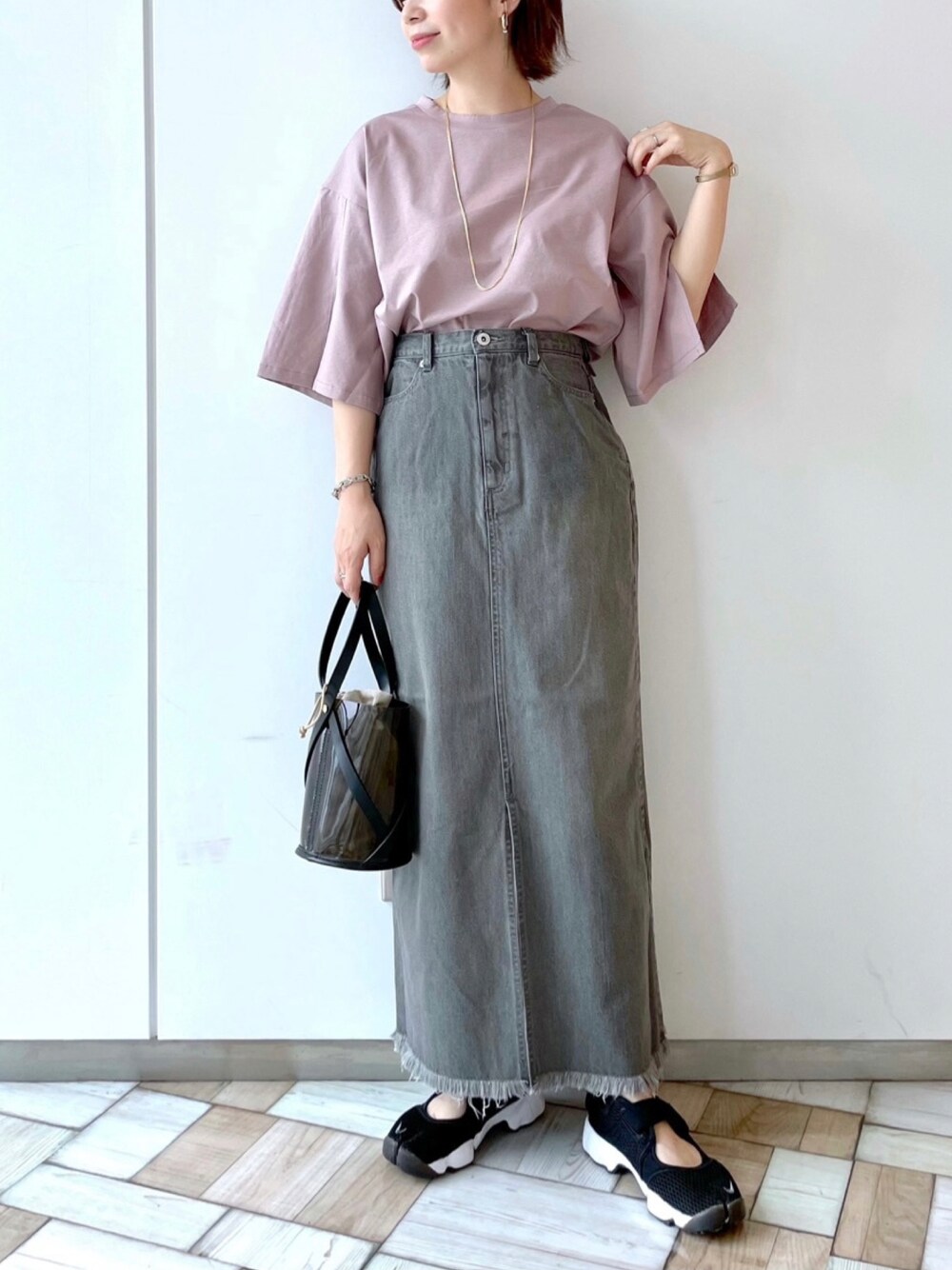 ピンク系のTシャツ/カットソー、グレー系のスカート、イエロー系のショルダーバッグを着用したレディースの夏コーディネートの1枚目の写真