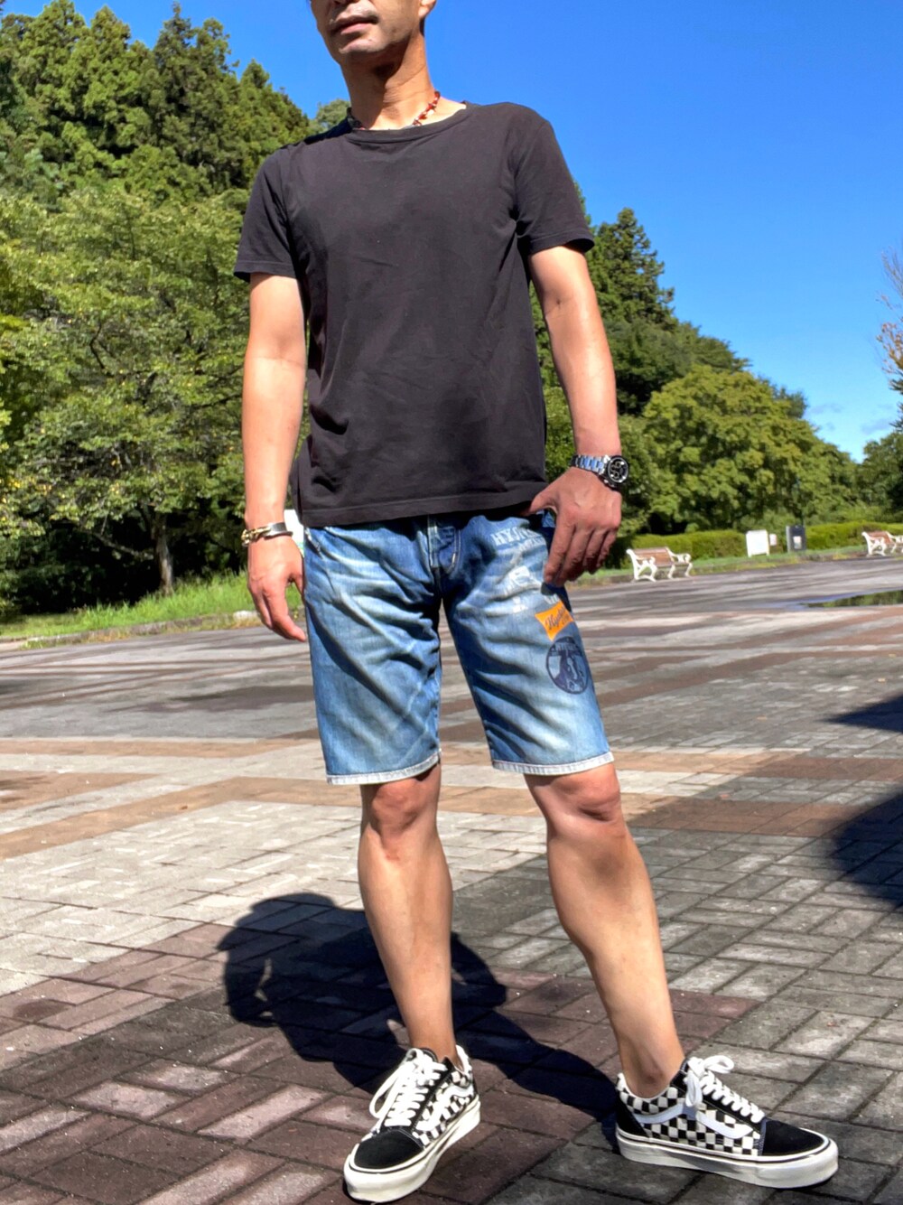 ブルー系のデニムパンツ、ブラック系のスニーカーを着用したメンズの秋コーディネートの1枚目の写真