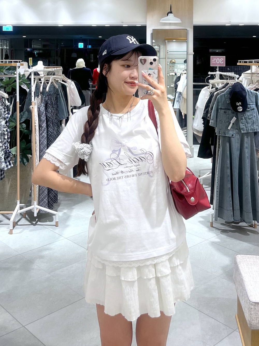 ホワイト系のキャミソール、ホワイト系のスカート、レッド系のボストンバッグを着用したレディースの春コーディネートの1枚目の写真