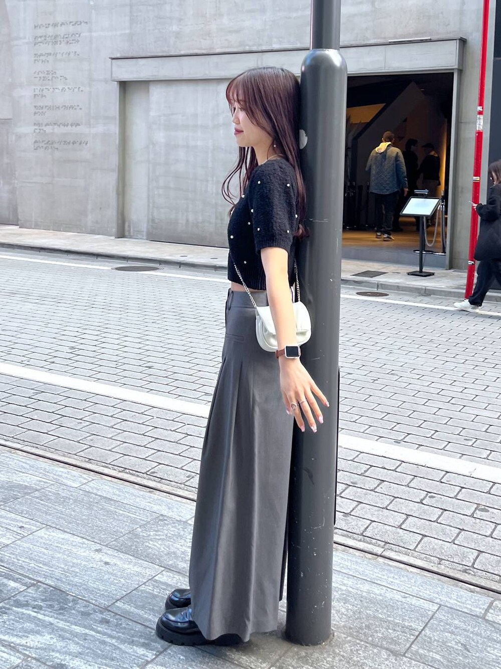 ホワイト系のショルダーバッグ、ホワイト系のキャミソール、ブラック系のローファーを着用したレディースの春コーディネートの1枚目の写真