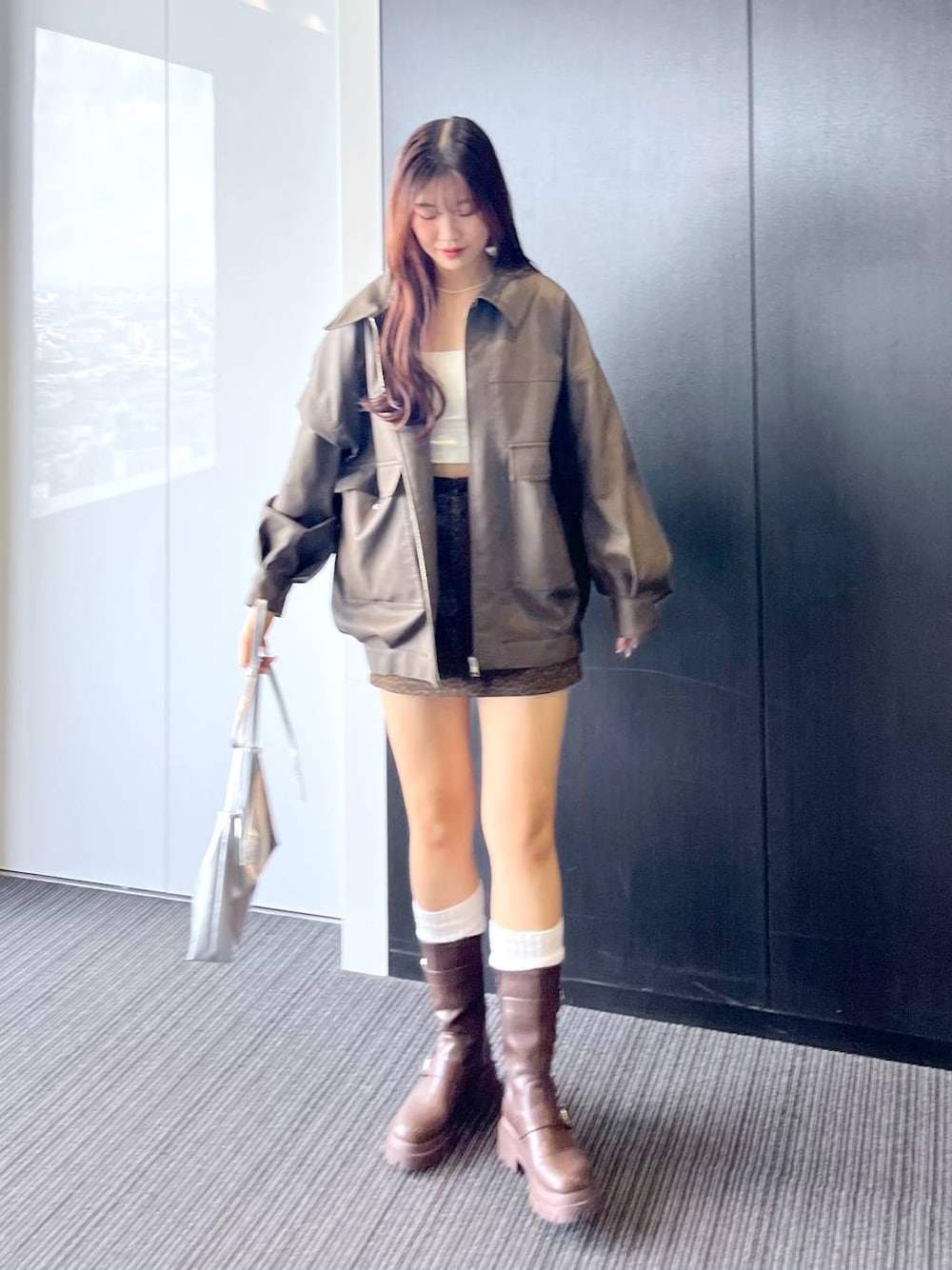 ブラウン系のブーツ、その他のスカート、シルバー系のショルダーバッグを着用したレディースの秋コーディネートの1枚目の写真