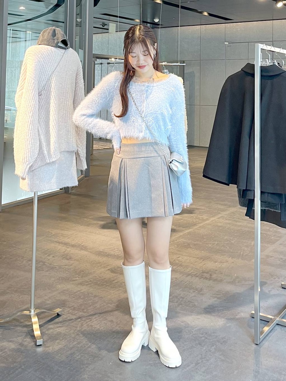 グレー系のスカート、ホワイト系のブーツ、ホワイト系のTシャツ/カットソーを着用したレディースの秋コーディネートの1枚目の写真