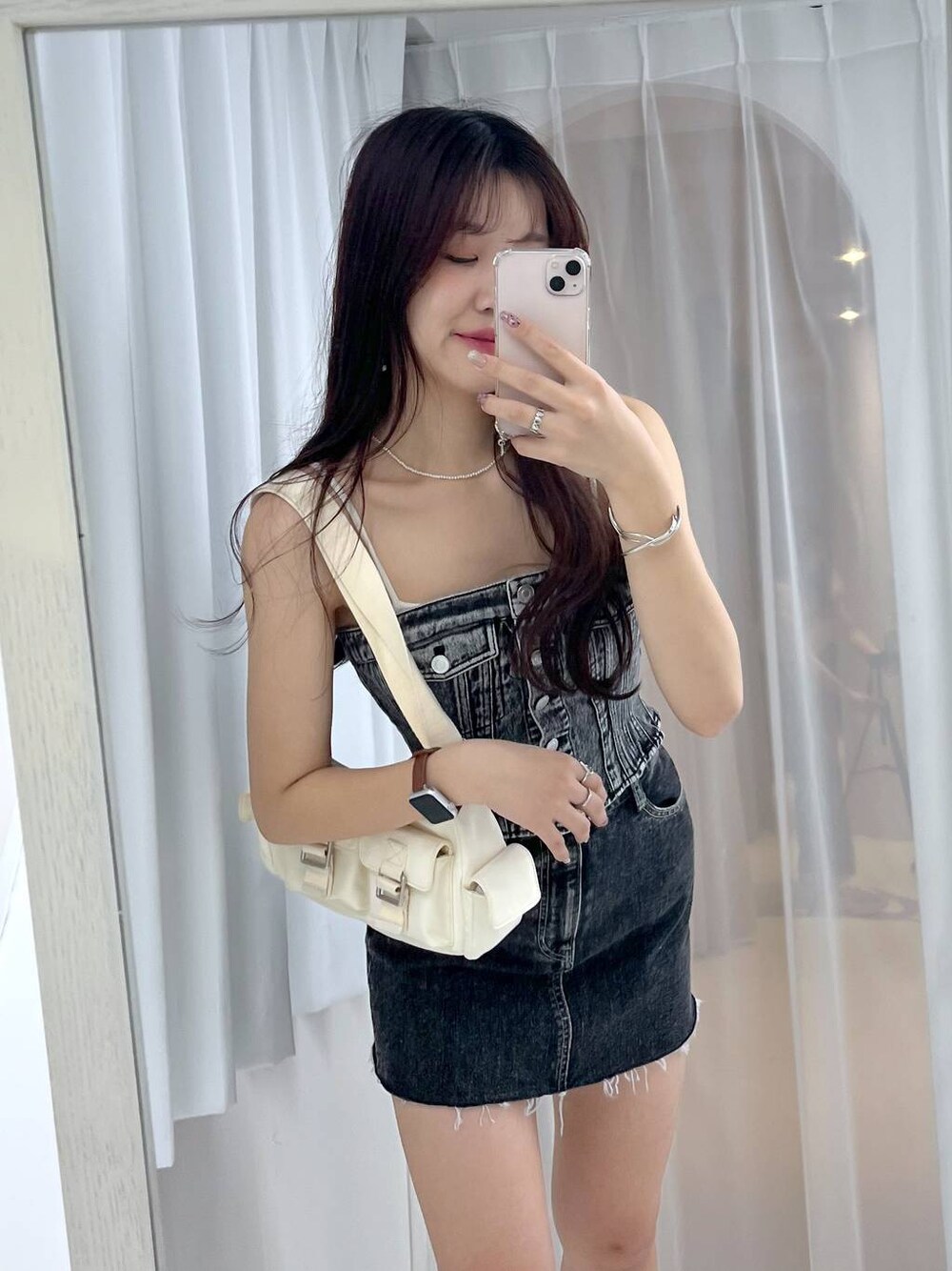 ホワイト系のショルダーバッグ、ブルー系のその他トップス、ブラック系のデニムスカートを着用したレディースの春コーディネートの1枚目の写真