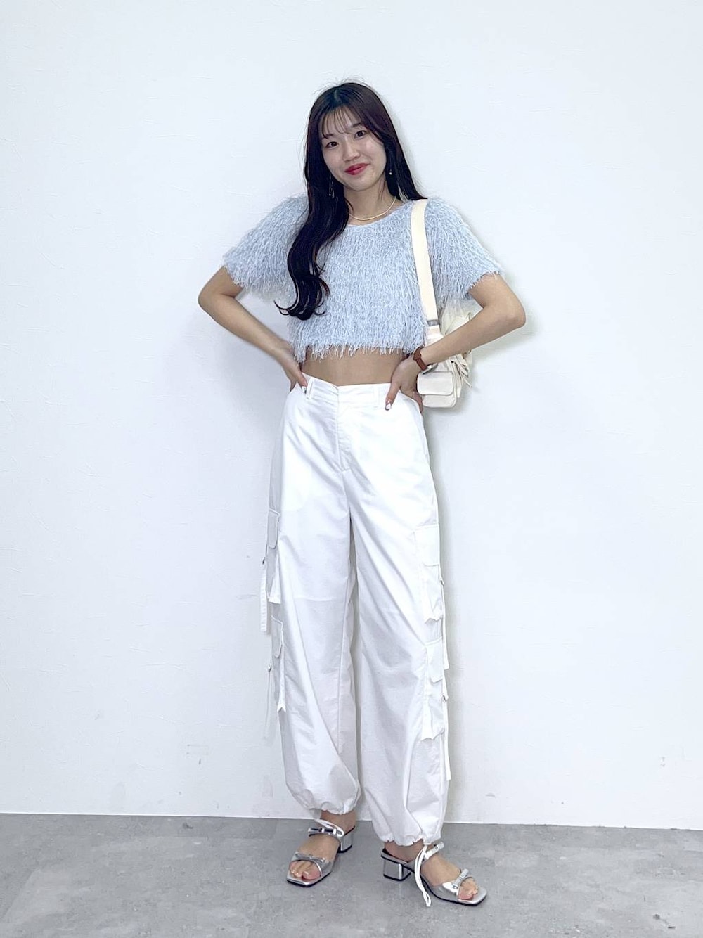 ホワイト系のショルダーバッグ、ホワイト系のキャミソール、ブルー系のTシャツ/カットソーを着用したレディースの春コーディネートの1枚目の写真