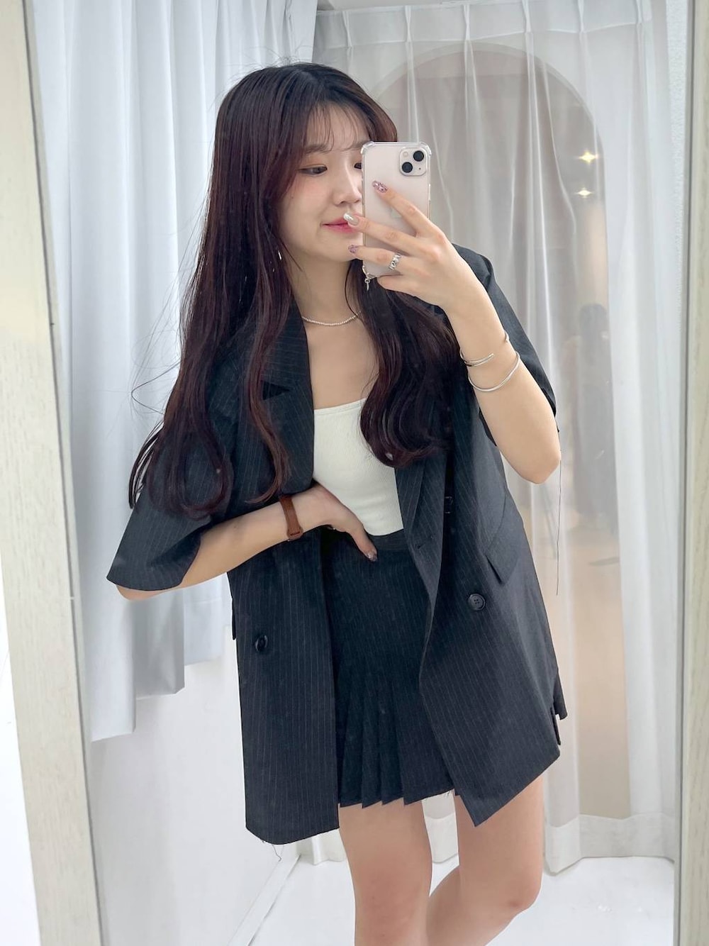 グレー系のスカート、ホワイト系のキャミソール、シルバー系のパンプスを着用したレディースの春コーディネートの1枚目の写真