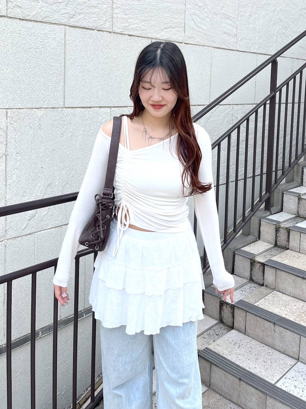 ホワイト系のキャミソール、ブルー系のデニムパンツ、ホワイト系のスカートを着用したレディースの春コーディネートの1枚目の写真