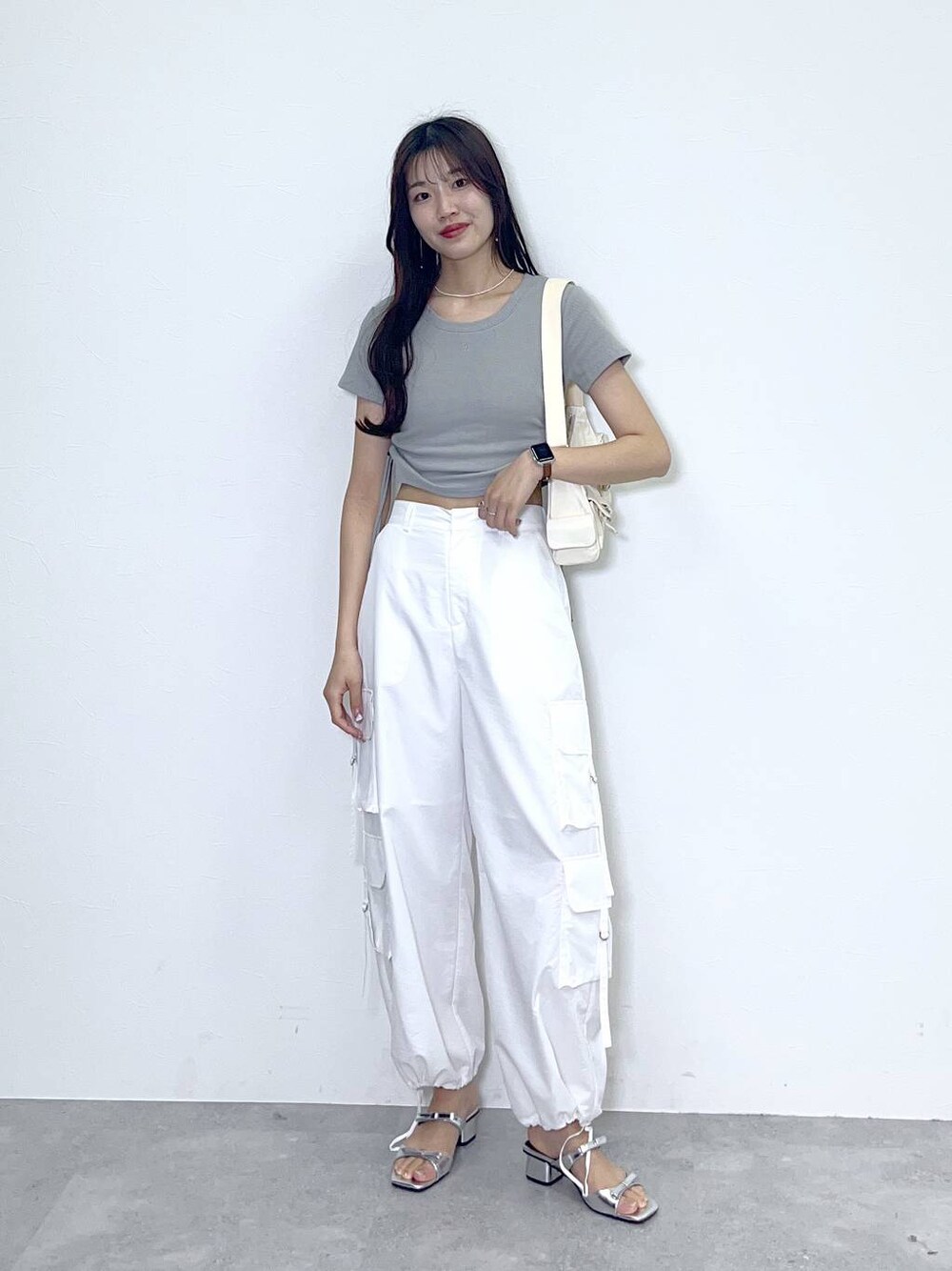 ホワイト系のショルダーバッグ、ホワイト系のカーゴパンツ、シルバー系のサンダルを着用したレディースの春コーディネートの1枚目の写真