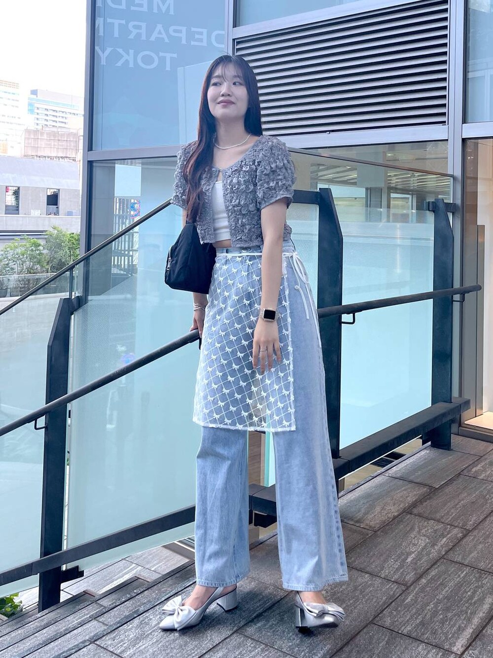 シルバー系のサンダル、ホワイト系のキャミソール、ブルー系のデニムパンツを着用したレディースの夏コーディネートの1枚目の写真