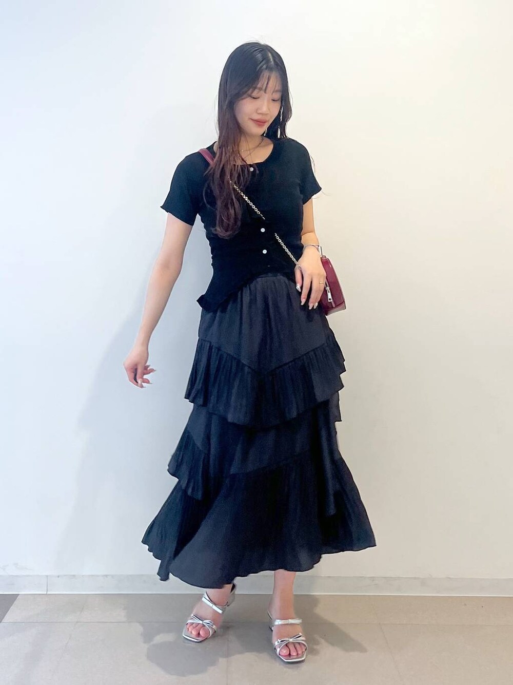 ホワイト系のキャミソール、ブラック系のスカート、シルバー系のサンダルを着用したレディースの春コーディネートの1枚目の写真