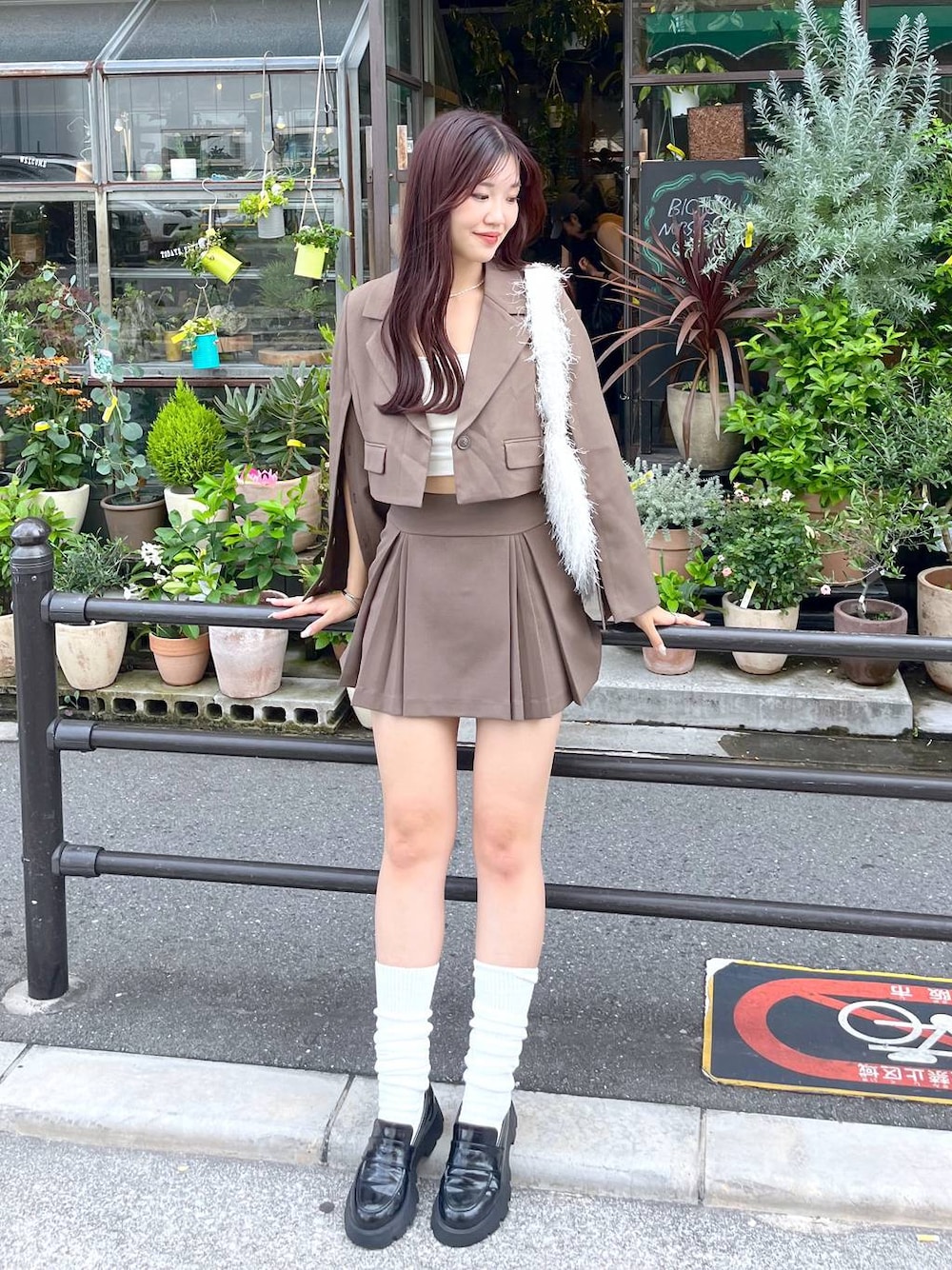 ブラウン系のテーラードジャケット、ブラウン系のスカート、ホワイト系のキャミソールを着用したレディースの夏コーディネートの1枚目の写真