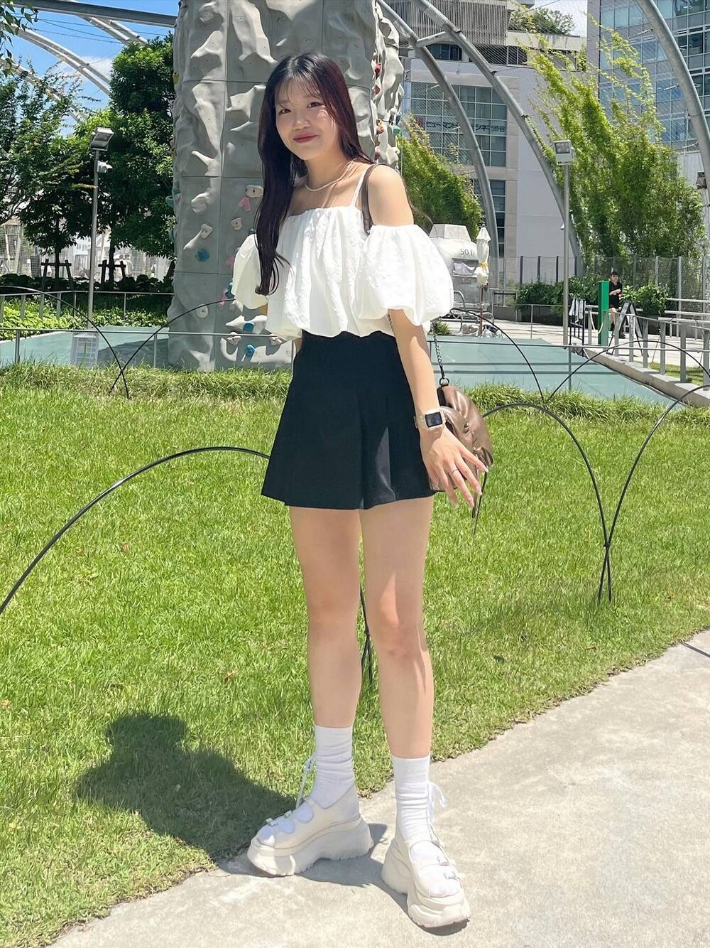 ブラック系のスカート、ホワイト系のシャツ/ブラウス、ホワイト系のキャミソールを着用したレディースの夏コーディネートの1枚目の写真