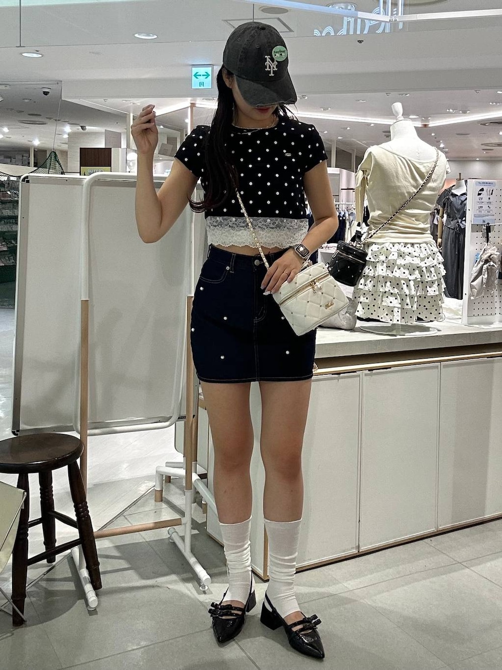 ホワイト系のショルダーバッグ、ブラック系のパンプス、ホワイト系のチューブトップを着用したレディースの夏コーディネートの1枚目の写真