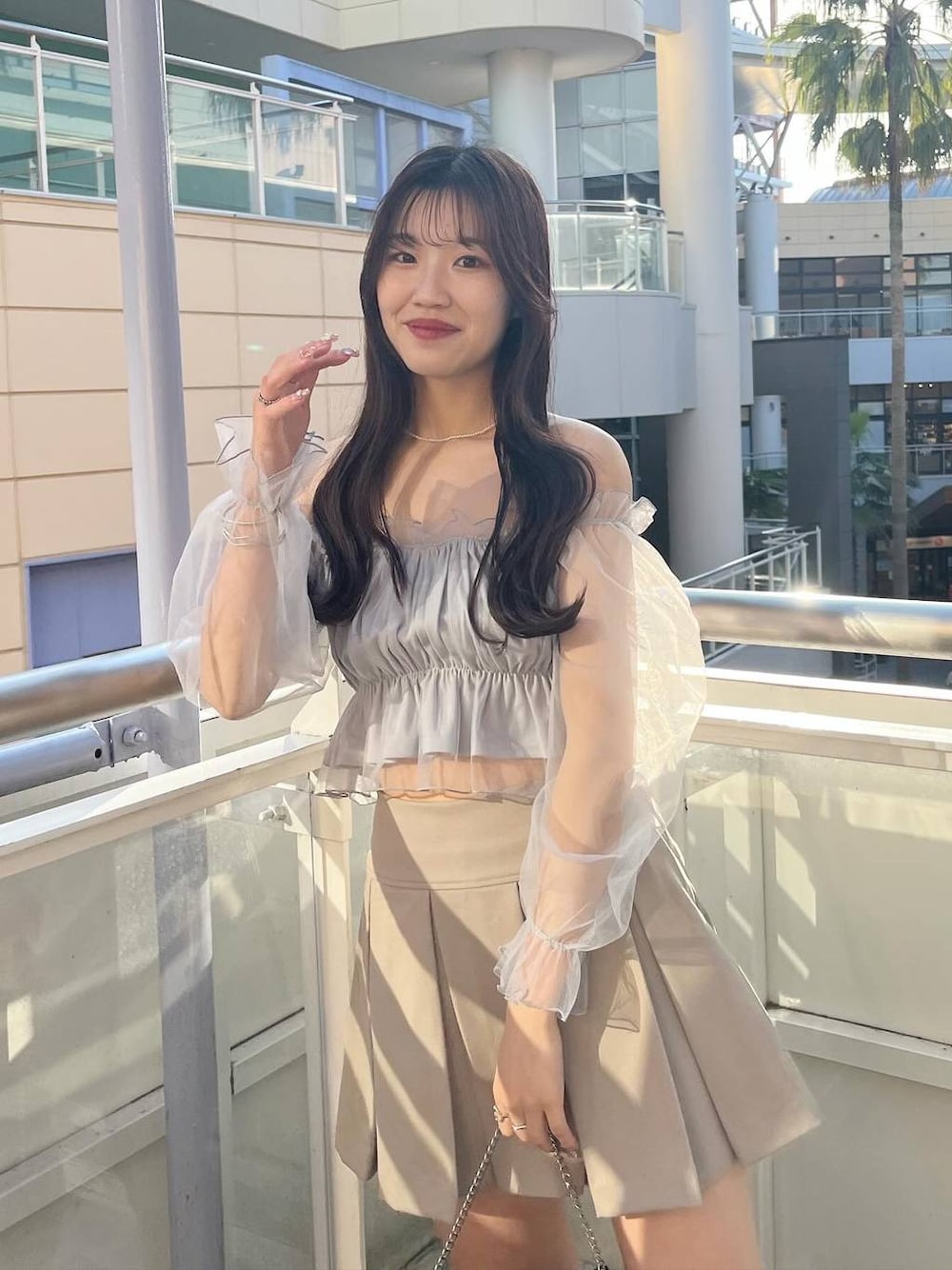 ブラック系のショルダーバッグ、グレー系のシャツ/ブラウス、ホワイト系のキャミソールを着用したレディースの春コーディネートの1枚目の写真