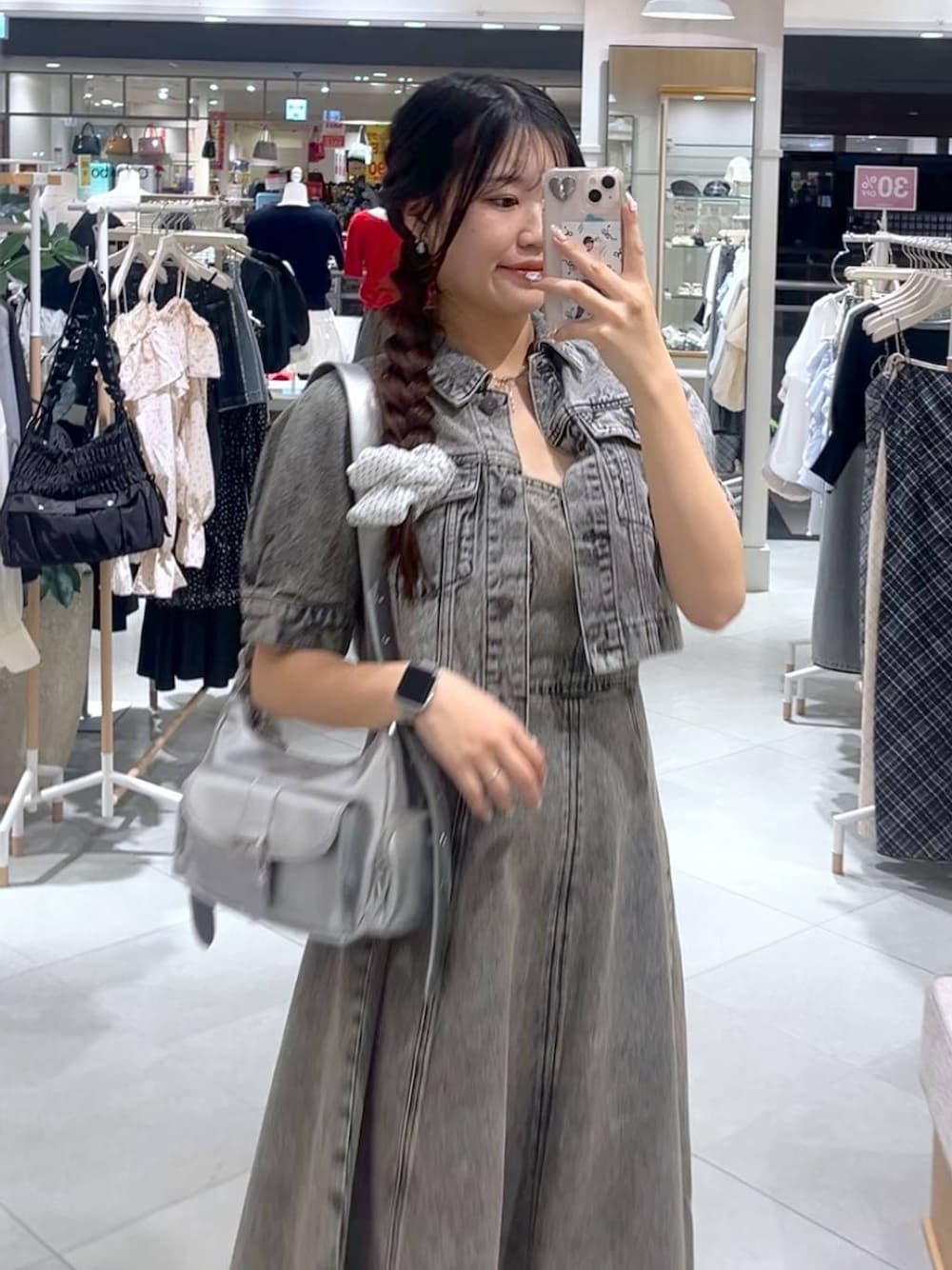 シルバー系のショルダーバッグ、グレー系のデニムジャケット、グレー系のワンピースを着用したレディースの春コーディネートの1枚目の写真