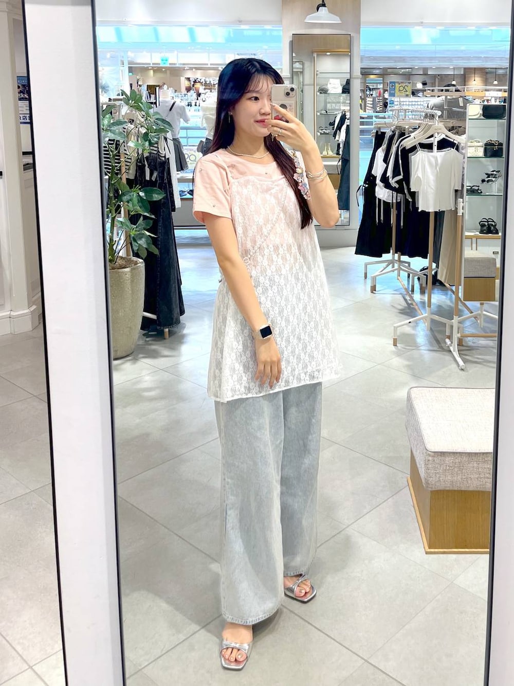 シルバー系のサンダル、ホワイト系のキャミソール、ブルー系のデニムパンツを着用したレディースの春コーディネートの1枚目の写真