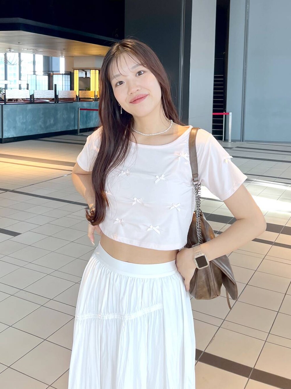 ピンク系のTシャツ/カットソー、ホワイト系のキャミソール、ブラウン系のショルダーバッグを着用したレディースの夏コーディネートの1枚目の写真