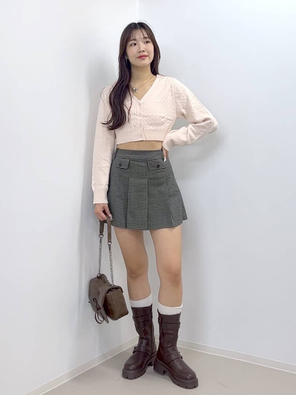 ブラウン系のショルダーバッグ、ブラウン系のブーツ、ホワイト系のキャミソールを着用したレディースの秋コーディネートの1枚目の写真