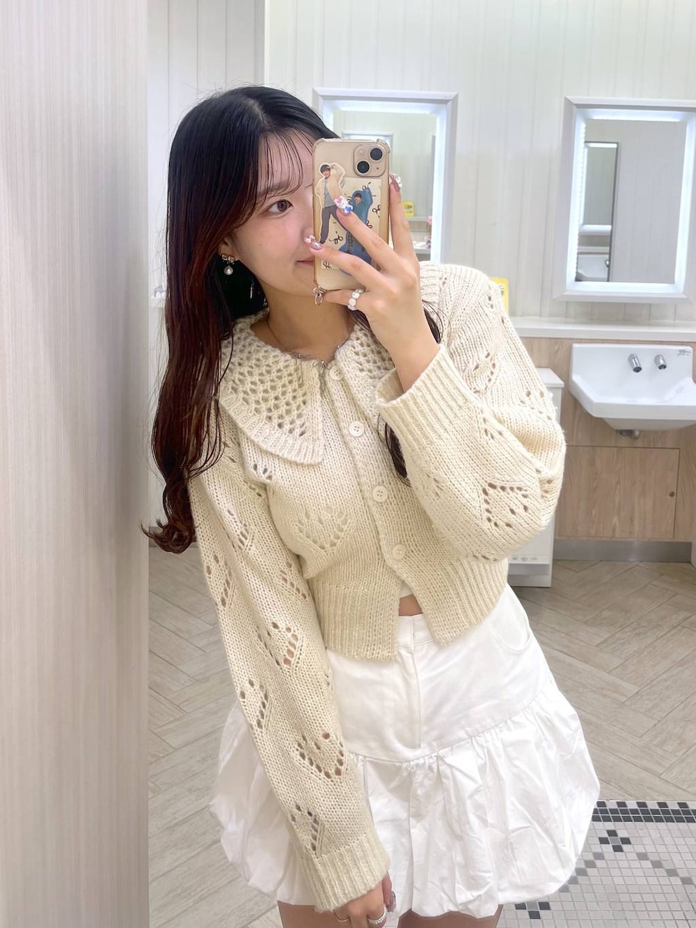 ホワイト系のキャミソール、ホワイト系のスカート、ホワイト系のカーディガン/ボレロを着用したレディースの冬コーディネートの1枚目の写真