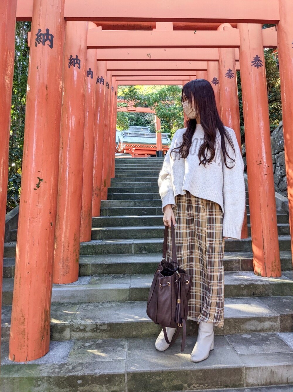 ホワイト系のニット/セーター、イエロー系のスカート、ホワイト系のブーツを着用したレディースの冬コーディネートの1枚目の写真