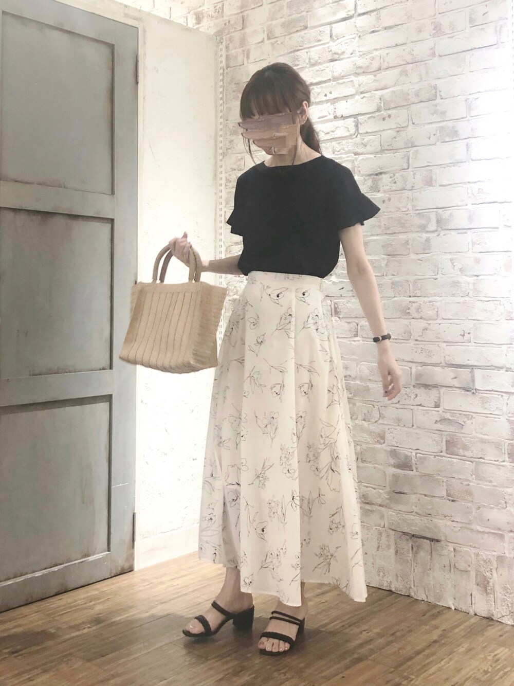 ブラック系のニット/セーター、ホワイト系のスカート、ブラック系のサンダルを着用したレディースの夏コーディネートの1枚目の写真