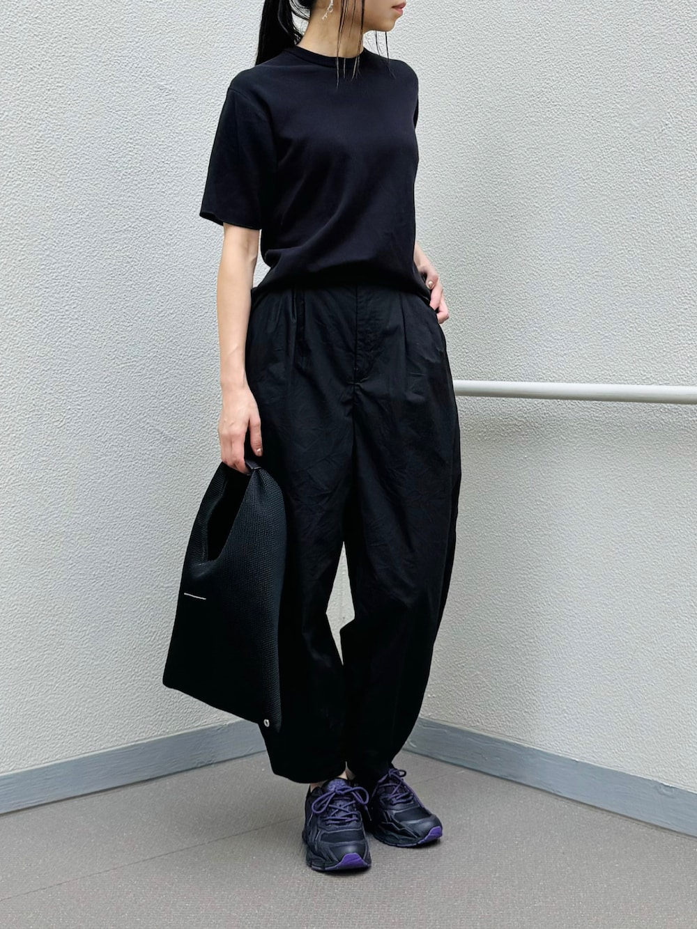 ブラック系のシューズ、ブラック系のトートバッグ、ブラック系のパンツを着用したレディースの夏コーディネートの1枚目の写真