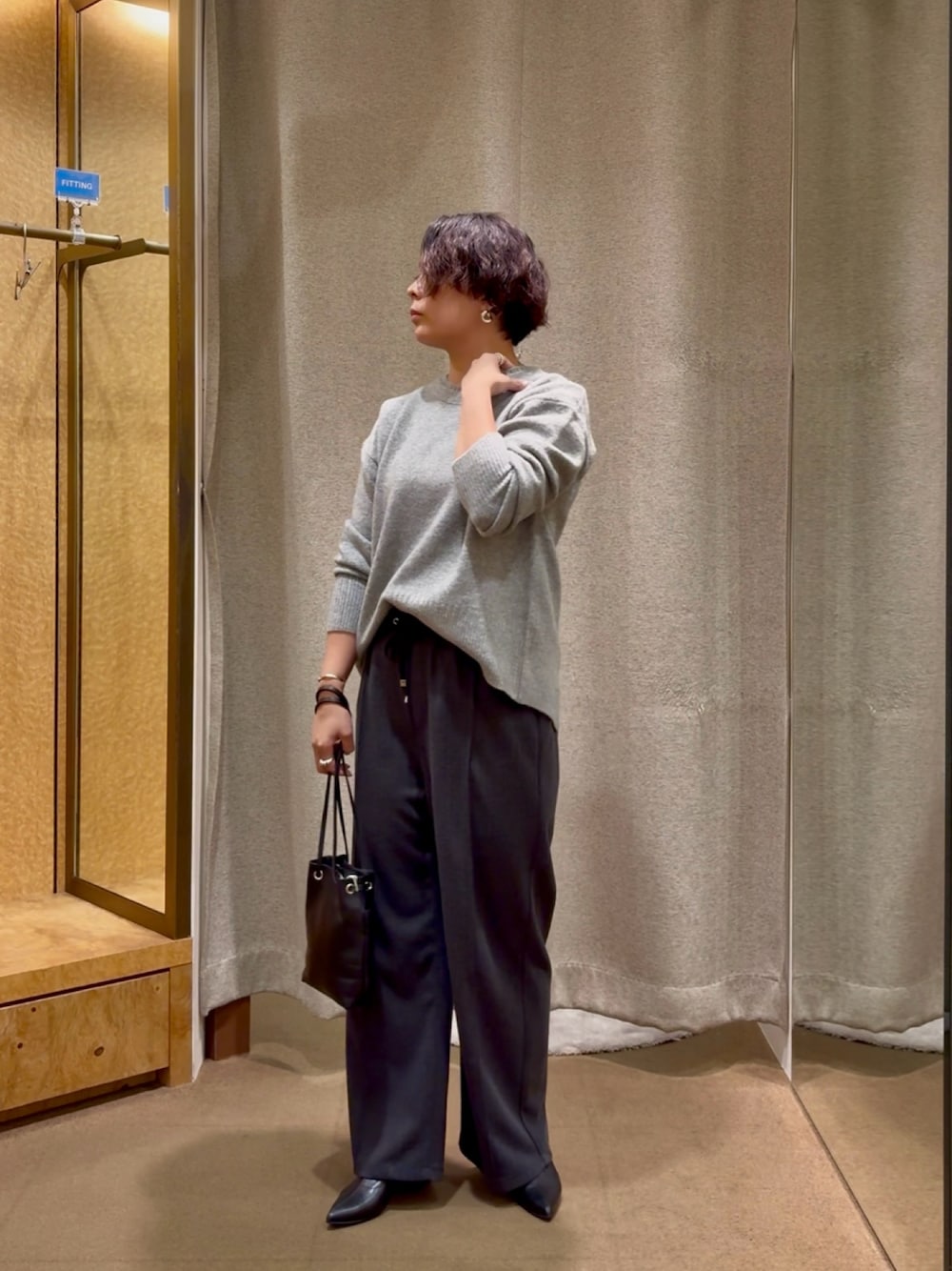 グレー系のニット/セーター、グレー系のその他パンツ、ブラック系のブーツを着用したレディースの秋コーディネートの1枚目の写真