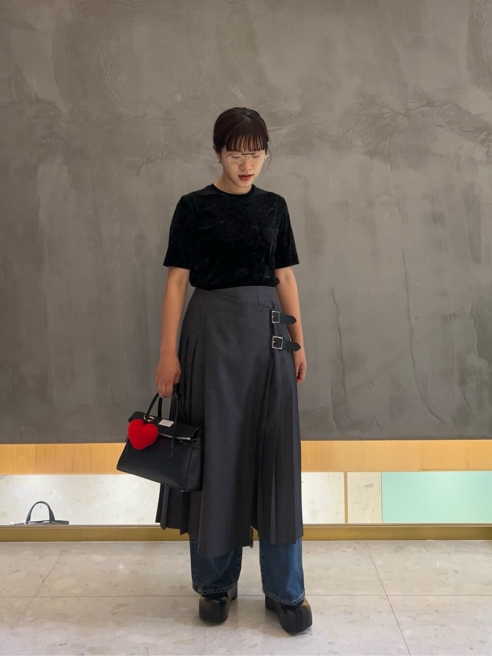ブラック系のTシャツ/カットソー、グレー系のスカートを着用したレディースの秋コーディネートの1枚目の写真